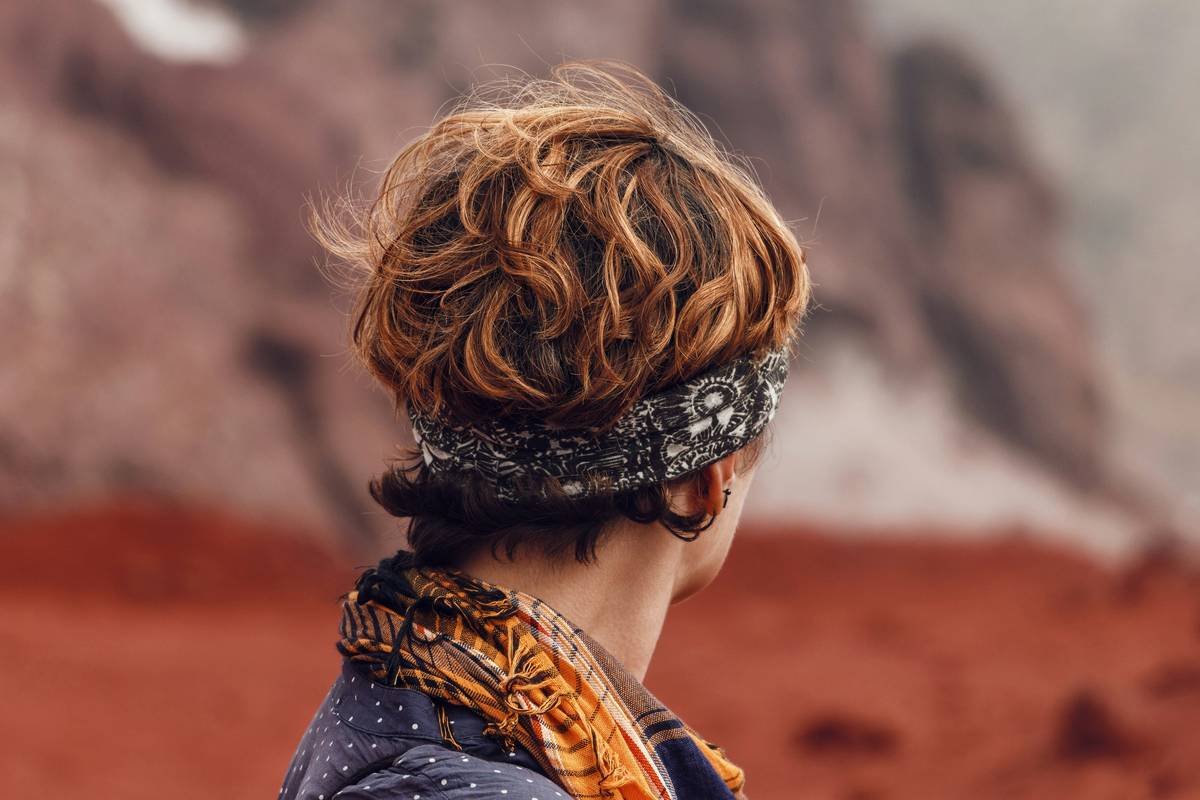 Two women wearing gym headbands while lifting weights in the gym.