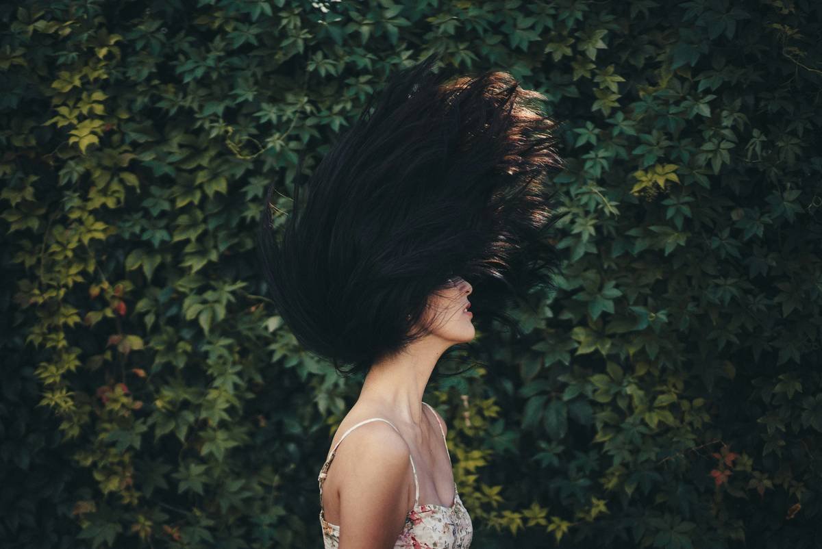Woman struggling with messy hair during exercise.