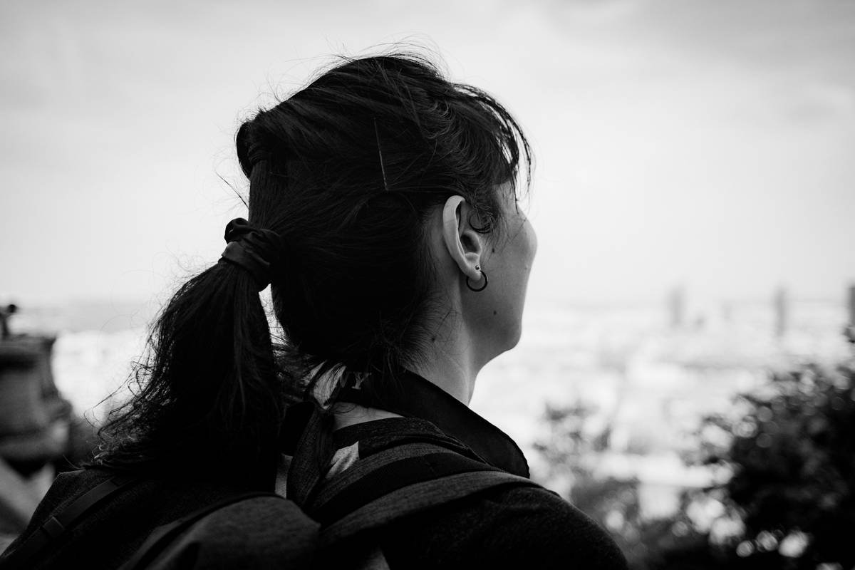 Infographic showing comparison between damaging vs. healthy fitness hairstyles: tight ponytail vs. loose twisted low bun with silk scrunchie, highlighting breakage zones and traction points on scalp.