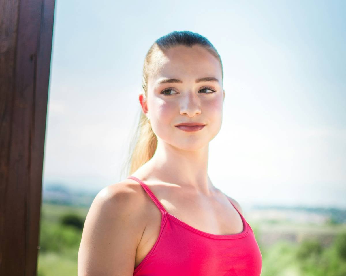 A young woman in a pink top outdoors